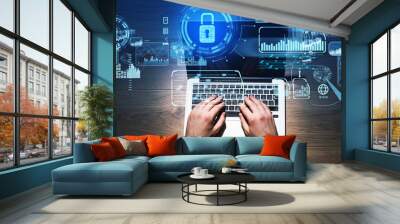 Top view of businessman working with laptop, blue glowing information protection icons. Padlock and interface. Concept of cyber security and data storage Wall mural