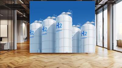 White hydrogen storage tanks with blue H2 labels, set against a blue sky with clouds, symbolizing clean energy. 3D Rendering Wall mural