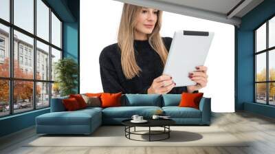 Woman in casual clothing holding a tablet while reading. Isolated on a white background. Concept of technology, reading, and modern communication Wall mural