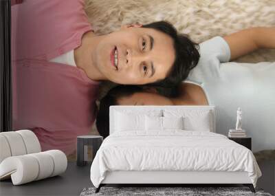 Man and woman lying down on carpet smiling Wall mural