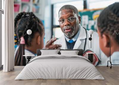 An eye doctor is pointing to an eye model to help students learn about the human eye. The model shows the different parts of the eye and how they work together. Wall mural