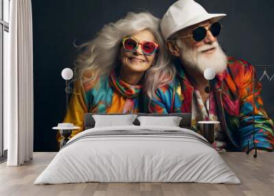 Happy elderly couple wearing colorful outfits and sunglasses. Wall mural