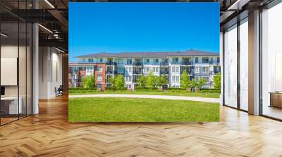 Concrete pathway across huge green lawn in front of residential condo building Wall mural