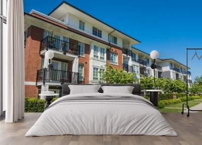 Luxury apartment building with green lawn in front Wall mural