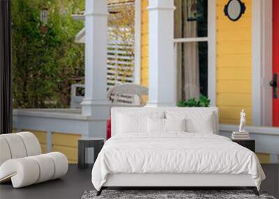 White chair with red pillow on the porch of historical residential house Wall mural