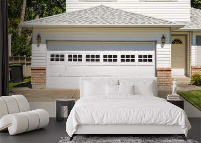 Wide garage door and concrete driveway in front of residential house Wall mural