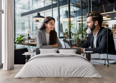 Business young man and a woman brainstorming with his colleague in an office. Brazilian woman and Brazlian man Wall mural