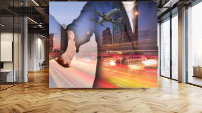 Double exposure of businessman handshake, airplane flying, light trails on street, city and urban in the night as business, commitment, welcome, congratulation, transportation and travel concept Wall mural