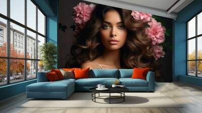 A beautiful woman with long, flowing brown hair adorned with pink flowers poses against a dark background Wall mural