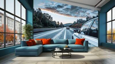 A car is driving down a highway with a beautiful blue sky in the background. The sky is filled with clouds, giving the scene a serene and peaceful atmosphere Wall mural