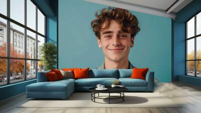 A multiracial young man with curly hair is smiling directly at the camera, exuding a friendly and approachable demeanor Wall mural