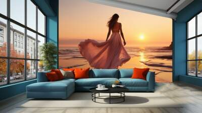 A woman in a long, pink dress walks along a sandy beach as the sun sets behind her. The dress flows in the breeze, creating a beautiful silhouette against the golden sky Wall mural