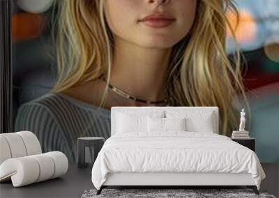 A woman with long blonde hair is wearing a gray shirt and a necklace. She has a pretty smile on her face Wall mural