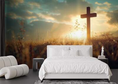 A wooden cross stands tall in a field of tall grass illuminated by the warm glow of the setting sun Wall mural