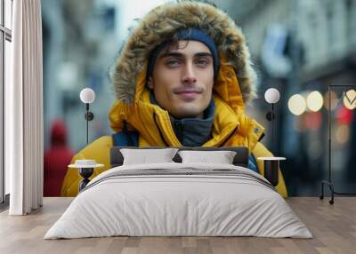 A young man wearing a bright yellow jacket with a fluffy hood walking in an urban area Wall mural