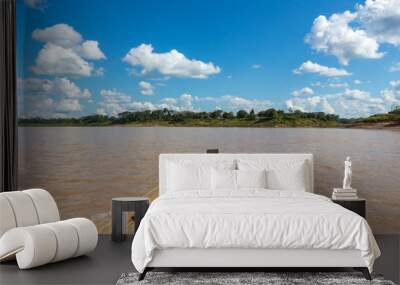 Inside view of rustic wooden motor boat sailing on Purus river in the Amazon on sunny summer day with trees on river bank, blue sky and clouds in the background. Nature and environment concept. Wall mural