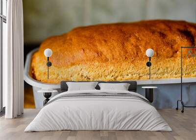 Shallow focus home baked bread still in aluminum baking pan. Golden brown crust with just the right texture for a crunchy bite. Wall mural