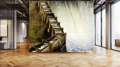 Wooden fish ladder with flowing water beside a reservoir overflow. This helps migrating fish to navigate obstacles in the main waterway. Lyckeby, Sweden. Wall mural