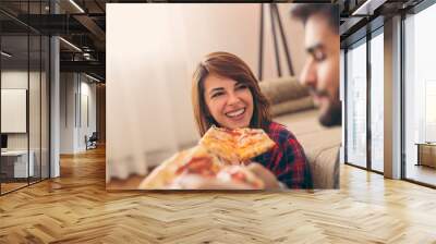 Couple eating pizza for lunch Wall mural