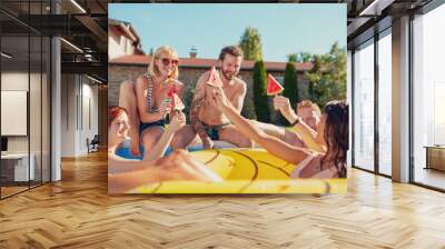 Friends spending hot summer day at the swimming pool, eating watermelon popsicles Wall mural