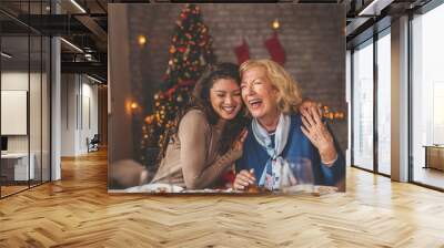 Mother and daughter hugging over Christmas dinner Wall mural