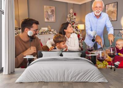 Senior man cutting chicken for family Christmas dinner Wall mural