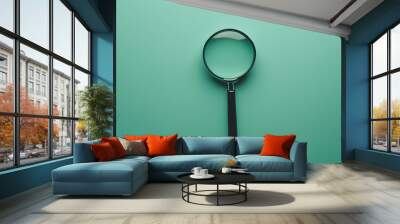 A magnifying glass positioned on a turquoise background from a top view, symbolizing search and discovery - Wall mural