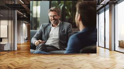 Mature businessman talking with younger colleague on couch with generative ai Wall mural