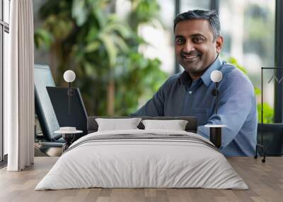 Smiling mature business man executive wearing shirt sitting at desk using laptop. Happy busy professional middle aged Indian businessman investor working on computer looking away in office, ai Wall mural