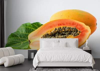 Half a ripe papaya with seeds and a whole papaya with a green leaf Wall mural