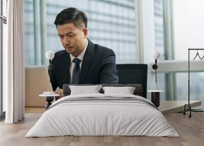 asian business man working in office using laptop computer Wall mural