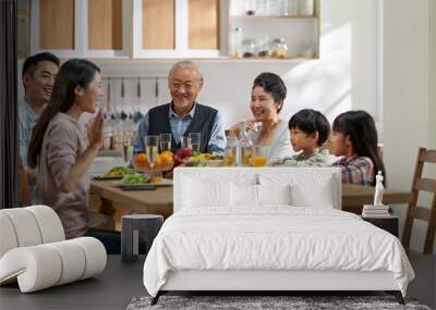 asian family chatting while eating meal Wall mural