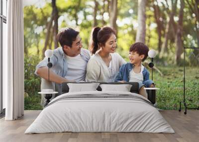 asian family with one child relaxing outdoors Wall mural