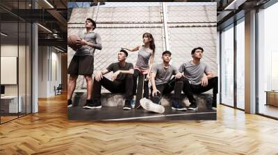 asian young adults resting relaxing on outdoor basketball court Wall mural