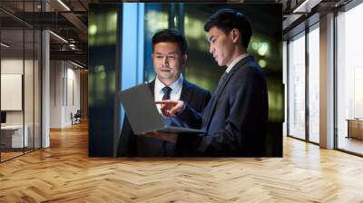 two asian businessmen discussing business in office using laptop computer Wall mural