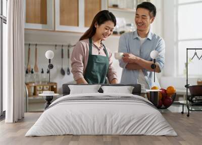 young asian couple talking chatting in kitchen Wall mural