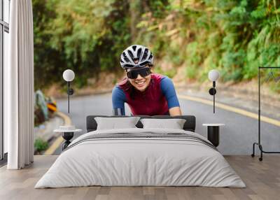 young asian woman riding bike outdoors on rural road Wall mural