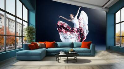 young ballerina in a beautiful dress is dancing in a dark photostudio Wall mural