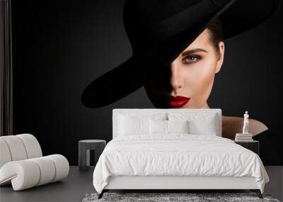 elegant woman face portrait hidden by black hat. beauty fashion model with red lips and eye make up  Wall mural