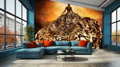 Fashion Model in Golden flying Dress looking away at Light. Afro Style Woman in Gold Long Gown fluttering on Wind rear view. Exotic Dancer with Silk Fabric over Art Fantasy Background Wall mural