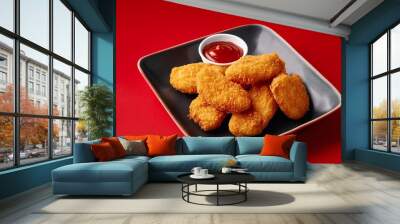 Spicy fried crispy chicken nuggets on red background Wall mural