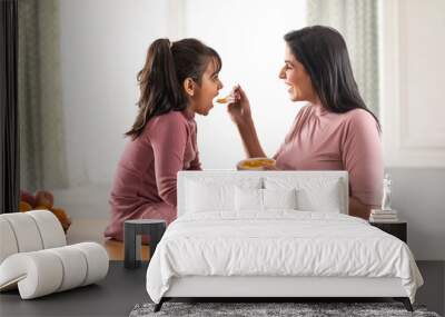 a daughter happily eating cornflakes given by mother Wall mural