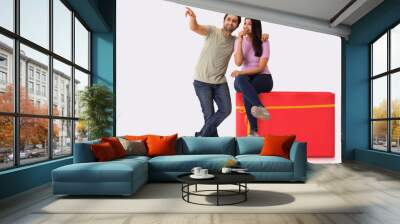 A young man showing something to the woman sitting on gift shaped stool beside him. Wall mural