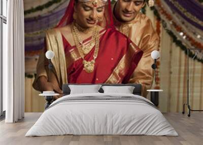 Bengali bride and groom making an offering  Wall mural