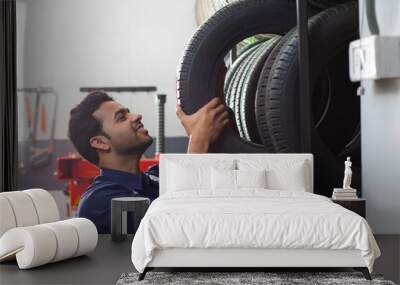 Mechanic selecting tyres at a tyre shop	 Wall mural