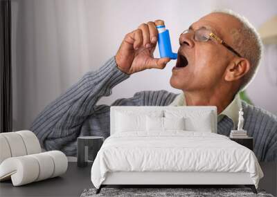 Old age man using her Asthma Inhaler at home Wall mural