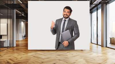 Portrait of a man in formal business suit with a laptop pointing sideways. Wall mural