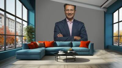 Portrait of a smiling businessman in eyeglasses with arms crossed 
 Wall mural