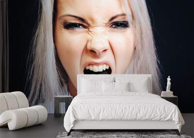 Young woman with painted Germany flag on the protruding tongue, black background. Wall mural