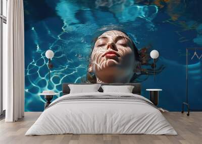 High angle view of woman relaxing in the swimming pool under clear blue water with closed eyes. Female face out of water, summer vacation concept.  Wall mural